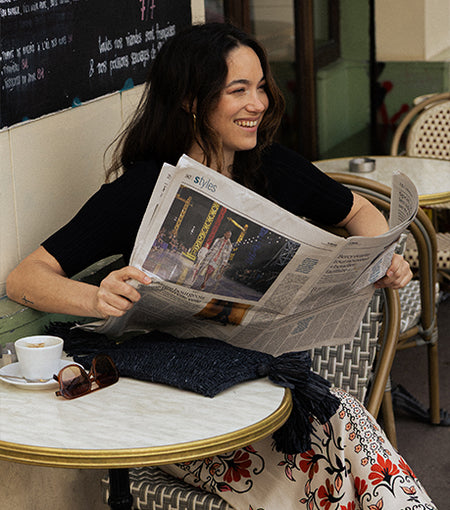 Image de Justrine dans un café habillé en pull west et pantalon cléliana 