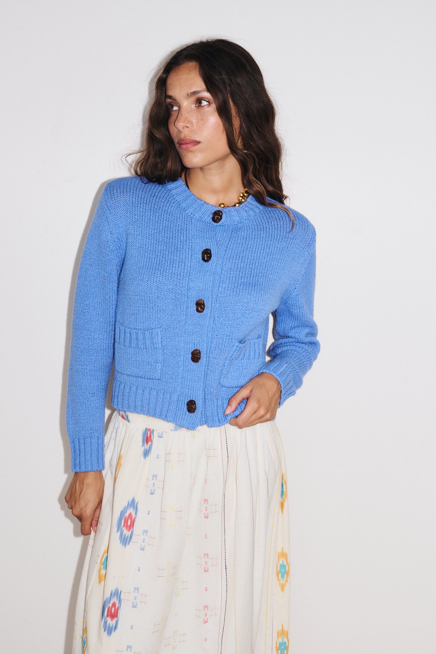 Zoom sur les détails du gilet Aza Stella Forest en maille douce coloris bleu clair, fermeture boutonnée et poches plaquées.