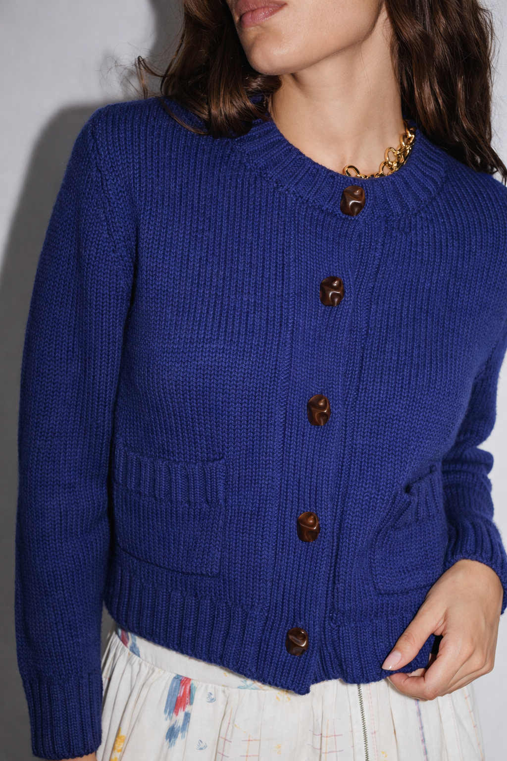 Zoom sur la maille texturée et les boutons travaillés du gilet Aza Stella Forest, couleur bleu indigo