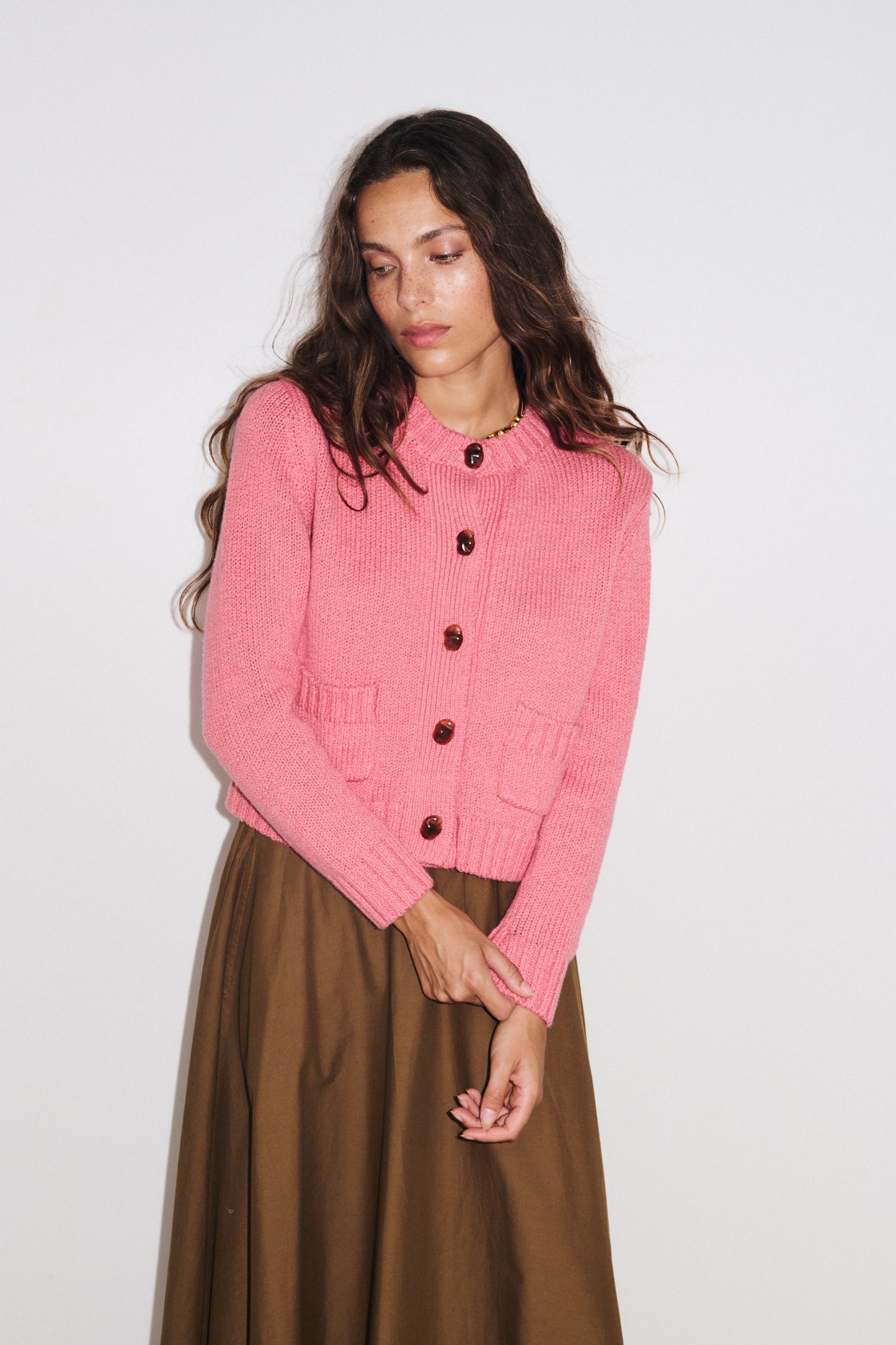 Zoom sur les détails du gilet Aza Stella Forest en maille douce coloris rose bonbon, fermeture boutonnée et poches plaquées.