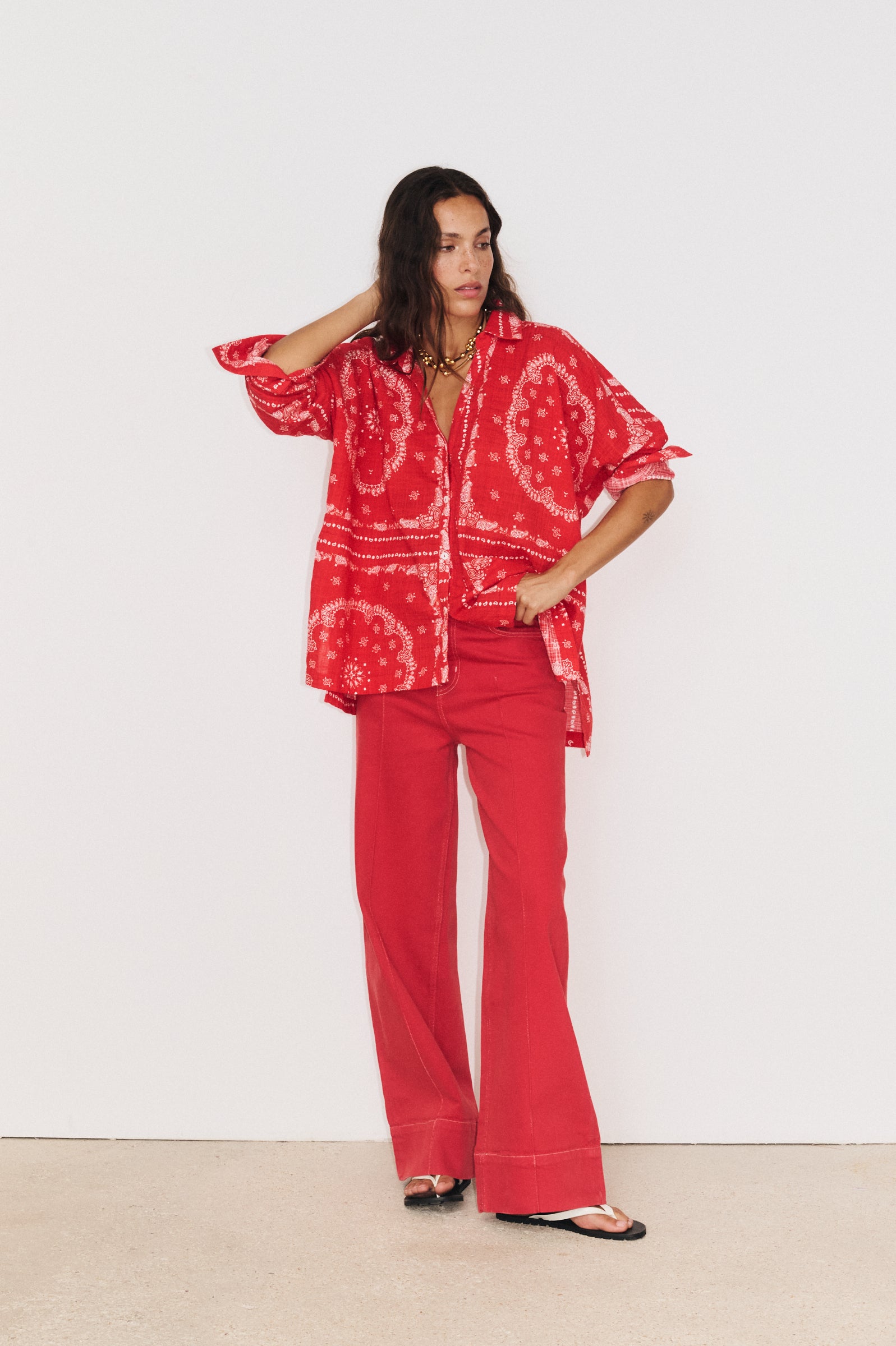 Détail du tombé fluide de la chemise en coton et viscose portée avec le pantalon Juliette rouge 

